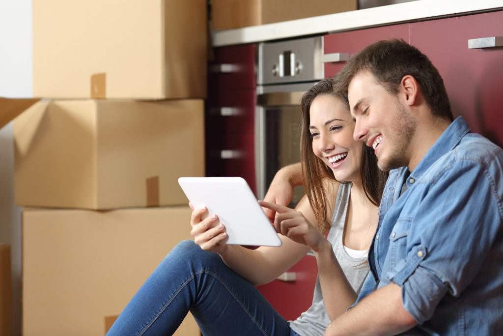 couple with mobile device and moving boxes